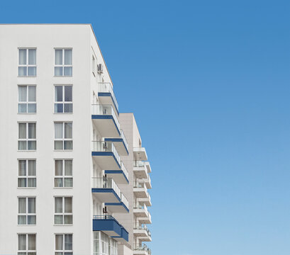 Apartment residential house or block of flats with balconies at clear blue sky background