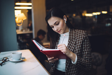 Smart formal woman taking notes in cafe
