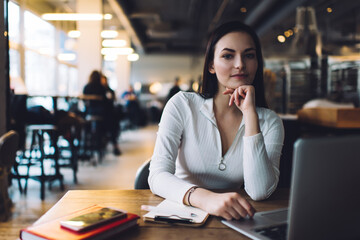 Calm female remote worker in cafe during workday