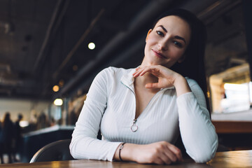 Smiling woman sitting at table in cafeteria