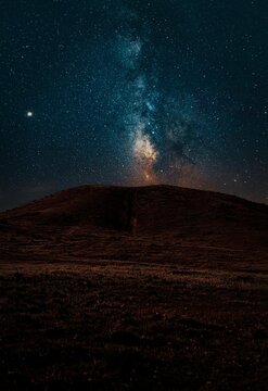 Milky way above dark landscape with Venus and colors 