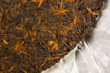 Chinese pressed PU-erh tea on wrapping paper, close-up, macro