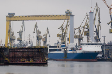 Fototapeta premium SHIPYARD - Ship on the background of industrial infrastructure 