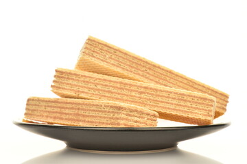 Three sweet vanilla waffles on a black saucer, close-up, isolated on white.