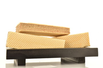 Three sweet vanilla waffles on a black wooden tray, close-up, isolated on white.