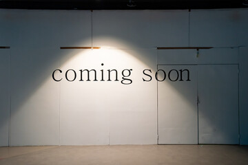 COMING SOON word on white background in the tungsten light on the wood cover fence or facade retail...