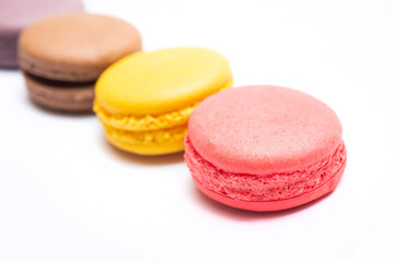 Various flavors of pastel macarons stacked against isolated on white background. Macarons is a...