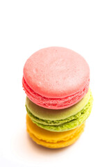 Various flavors of pastel macarons stacked against isolated on white background. Macarons is a delicate meringue-based cookie sandwich It is a dessert of French origin.