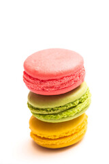 Various flavors of pastel macarons stacked against isolated on white background. Macarons is a delicate meringue-based cookie sandwich It is a dessert of French origin.