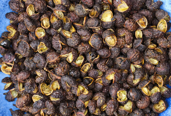 Macro full frame closeup of raw brown whole chinese sichuan timut pepper corns with citrus anise...
