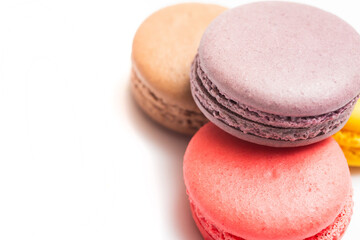 Various flavors of pastel macarons stacked against isolated on white background. Macarons is a...