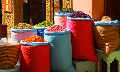 View on colorful sacks with oriental spices and dried fruits outside shop entrance on souk market -...