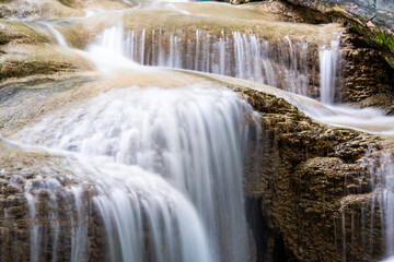 Naklejka premium Waterfall and blue emerald water color in Erawan national park. Erawan Waterfall, Beautiful nature rock waterfall steps in tropical rainforest at Kanchanaburi province, Thailand