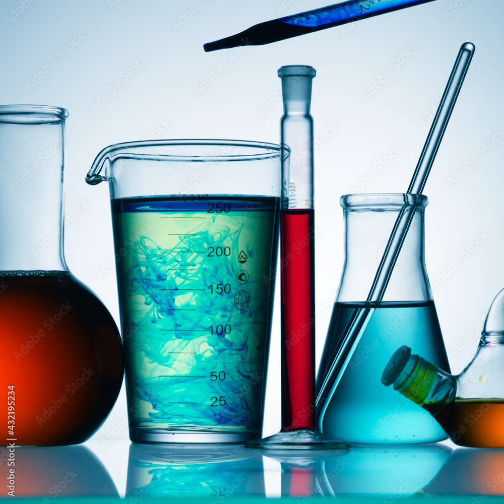 Wall mural different laboratory glassware with color liquid and with reflection