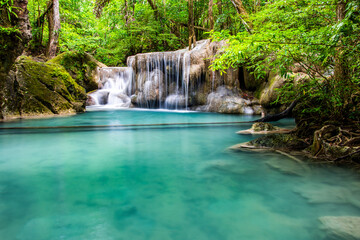 Naklejka premium Waterfall and blue emerald water color in Erawan national park. Erawan Waterfall, Beautiful nature rock waterfall steps in tropical rainforest at Kanchanaburi province, Thailand