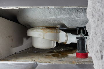 Leaking siphon of a shower tray in the bathroom, causes water damage. Tiles and masonry were...