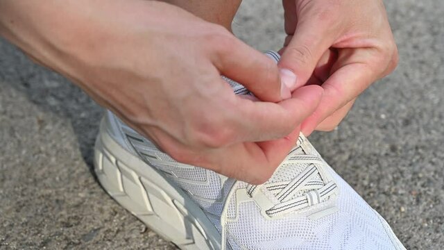 Close up of runner getting ready to tying shoelaces before running workout.