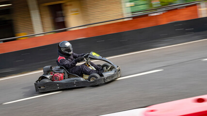 A panning shot of a racing kart as it circuits a track.