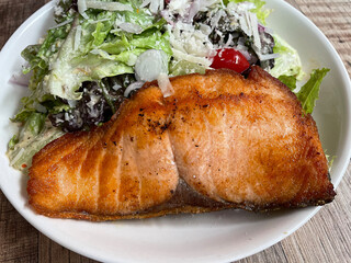 Top view Salmon fillet with salad on wooden table.