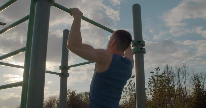 Athletic man doing strength training outdoors. Daily exercise to keep fit.