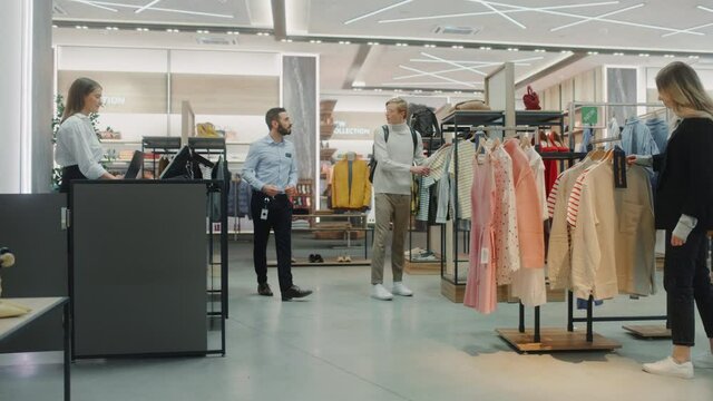 Customers Shopping in Modern Clothing Store, Retail Sales Associate Assists Clients. Diverse People in Fashionable Shop, Choosing Stylish Clothes, Colorful Brand Designs, Quality Sustainable Materials