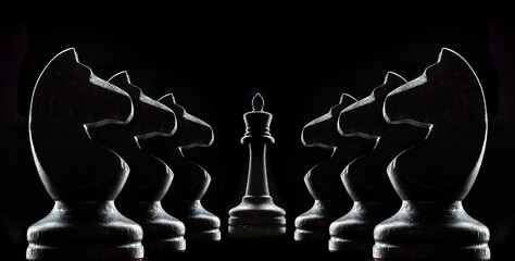 Silhouettes of chess on a black background.