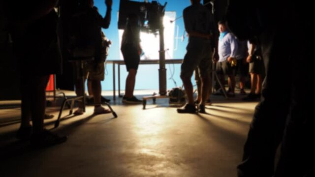 Blurred footage of behind the scenes. Video production shooting behind the scene or b-roll for online movie. Filming by director and film crew team with camera equipment lighting set. Video production