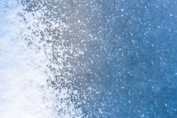 Ice on a pond covered with snow. Close up view from above