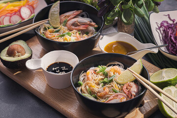 Asian dinner for two. Asian cuisine, rice noodles with seafood and vegetables