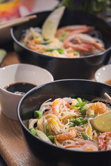 Asian dinner for two. Asian cuisine, rice noodles with seafood and vegetables