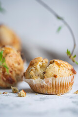 Savory cheese muffins on white table, spring background. Homemade salty muffins with herbs and bacon. Selective focus, copy space.