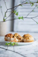 Savory cheese muffins on white table, spring background. Homemade salty muffins with herbs and bacon. Selective focus, copy space.