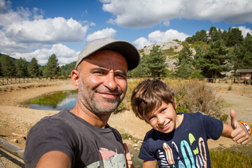 Little boy with his dad taking selfie in the nature