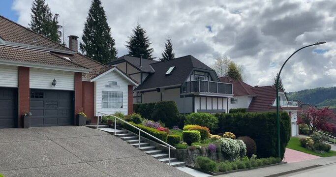 Establishing shot of two story stucco luxury house with garage door, big tree and nice landscape in Vancouver, Canada, North America. Day time on April 2021. Still camera view.