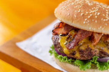 Hamburguesa con tocino frito queso derretido y vegetales frescos