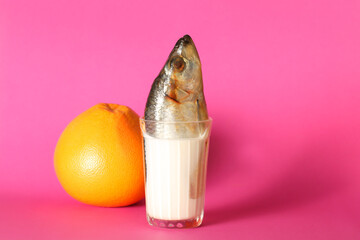 fish in a glass with milk on a bright background