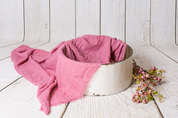 Decoración interior con madera blanca y cuenco de madera envejecida con foular rosa palo y ramo de flores