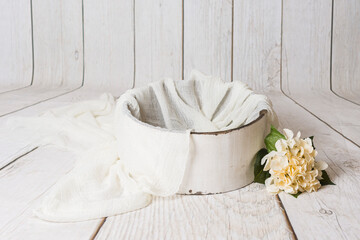 Decoración con cuenco de madera blanca envejecida con gasa blanca y ramo de flores