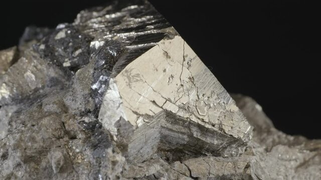 Pyrite dodecahedral crystals on hematite (also known as fool's gold or iron pyrite), isolated on a black background