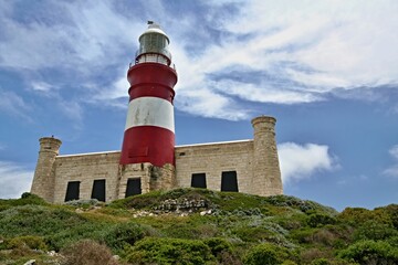 Fototapeta na wymiar Lighthouse on Cape Agulhas. The southernmost place of the African continent. Interface by Atlantic Ocean and Indian Ocean. South African Republic.