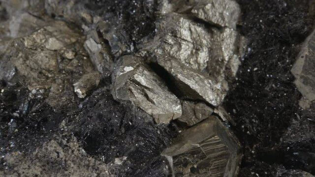 Pyrite dodecahedral crystals on hematite (also known as fool's gold or iron pyrite), isolated on a black background