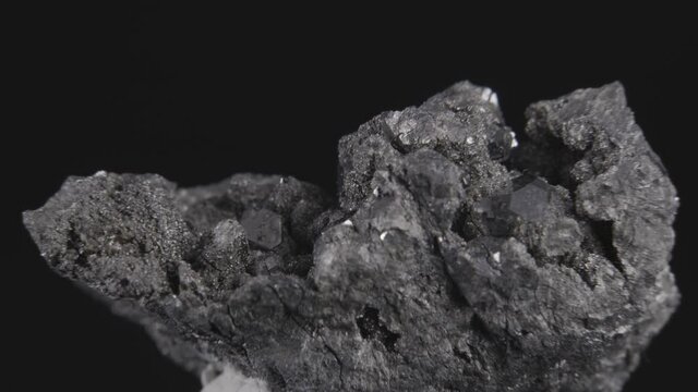 Skutterudite metal ore (containing nickel and iron) rotating on a black background, seamless loop