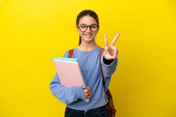 Student kid woman over isolated yellow background smiling and showing victory sign