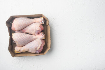 Fresh chicken leg, in paper Pack, on white stone  background, top view flat lay, with copy space for text