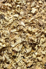 Background of large wooden shavings from chain saw. Production waste. Close-up. Selective focus.