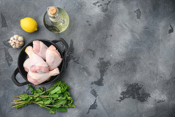 Fresh chicken legs and marinade ingredients, on frying cast iron pan, on gray background, top view flat lay, with copy space for text