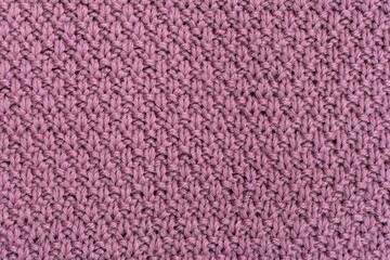 Knitted fabric pearl woolen background. The structure of the fabric with a natural texture. Fabric background. Knitted woolen background.