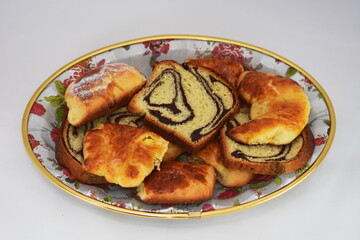 Breakfast. branzoici on a porcelain platter ,Croissants, donuts. romanian homemade  crullers 