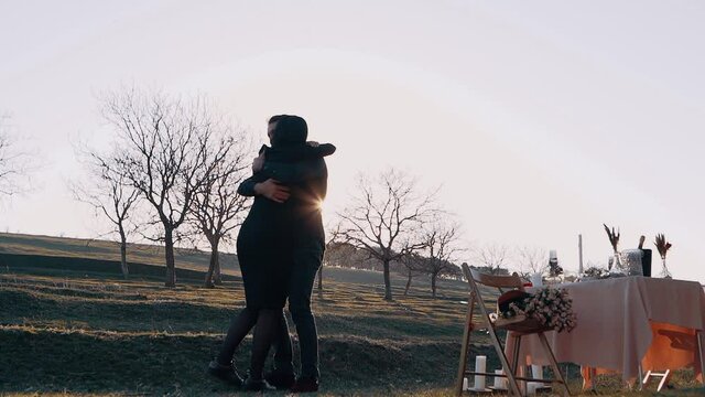 Young people in love kiss and hug tightly and are now engaged. The portrait of a couple in love who got engaged, in nature, under the sunset
