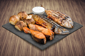 A selection of various barbecued gourmet meats on a black board with a rustic timber background. Assorted meat and fish